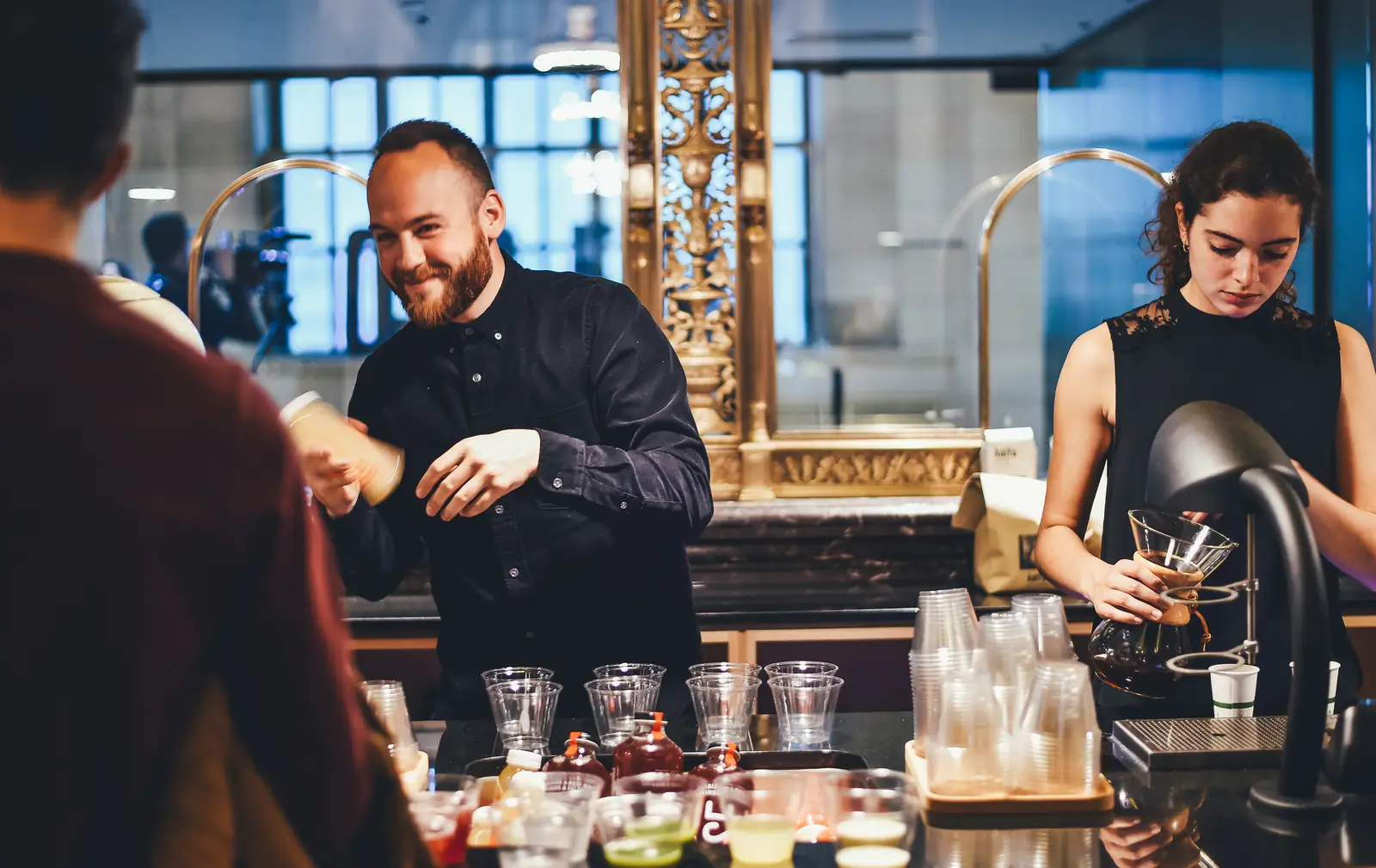 Le patron d'un café sert un client en souriant