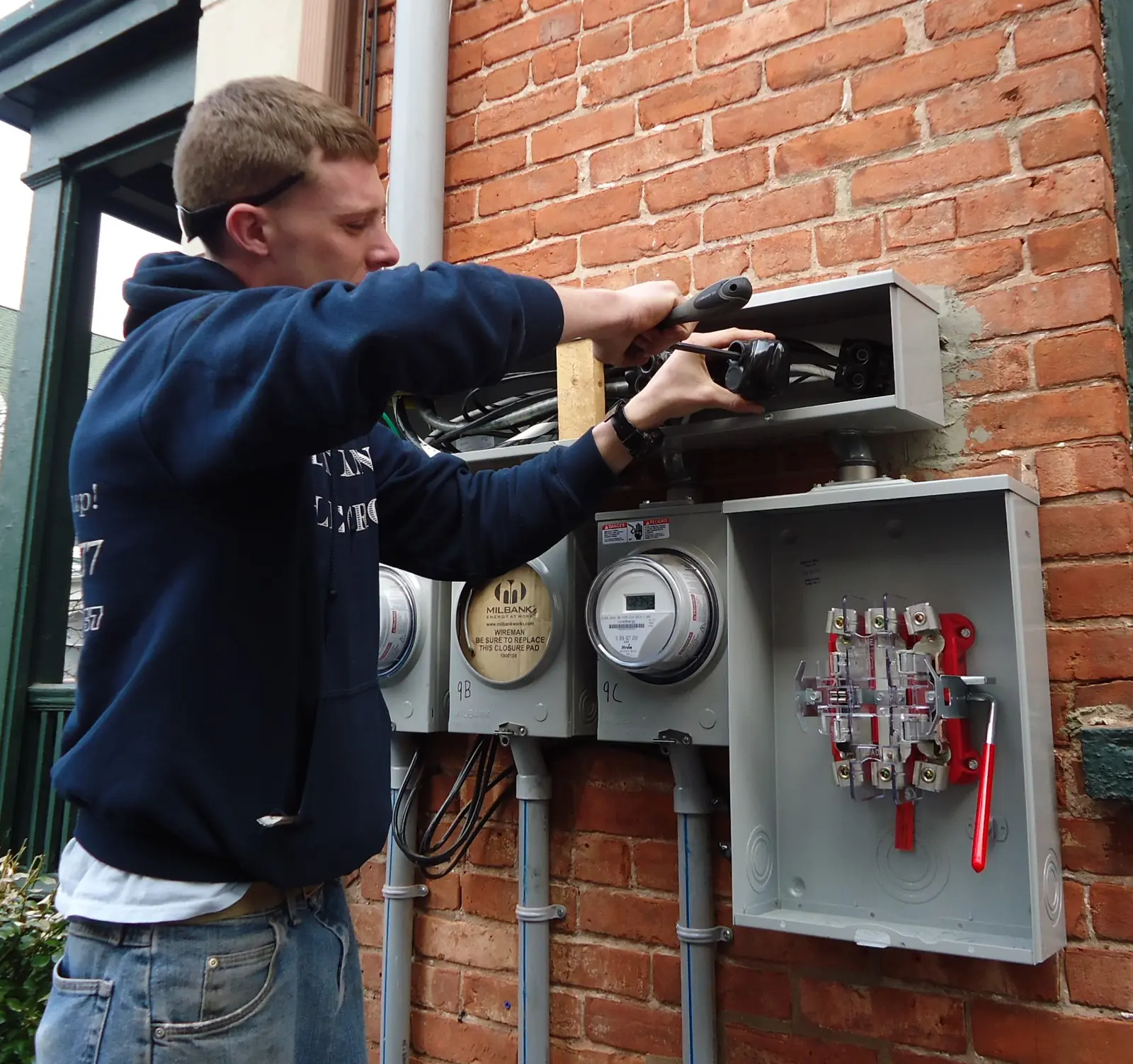 Un électricien au travail sur un tableau électrique