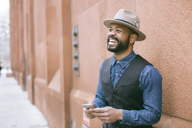 Un entrepreneur qui rit, téléphone en main
